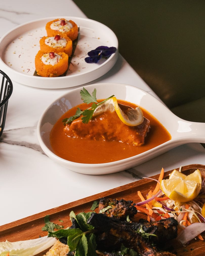 Three Indian dishes: sweet potato rolls, chicken curry, and grilled chicken with salad.